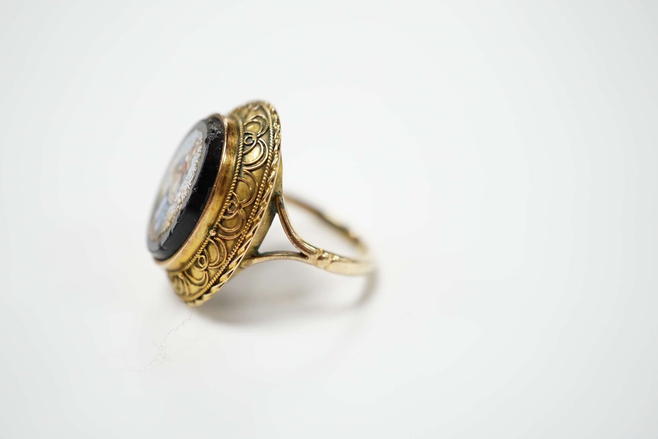 A 19th century yellow metal and oval micro mosaic set ring, depicting a warrior, size O.